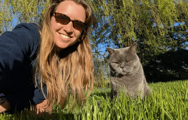 Petsitter Kelsey takes a selfie in the garden with the British Shorthair cat she’s looking after.