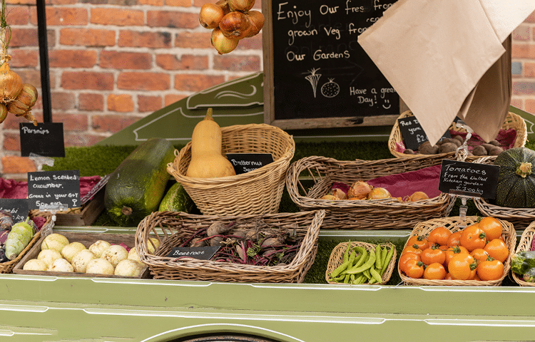 Small selection of fruit and vegetables for sale in small wicker baskets on a small holding farm